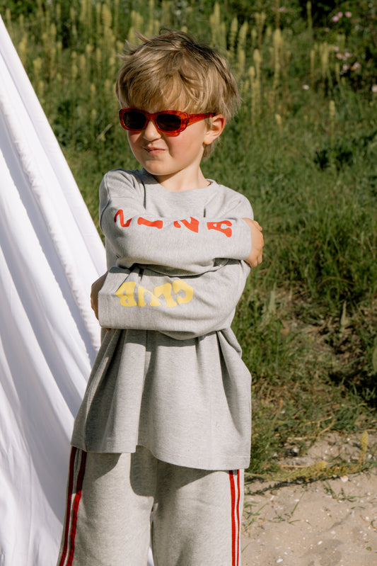 Kid wearing the ZIZA CLUB LS ZIZA CLUB Pepper, a grey melange oversized kids longsleeve with sleeve prints