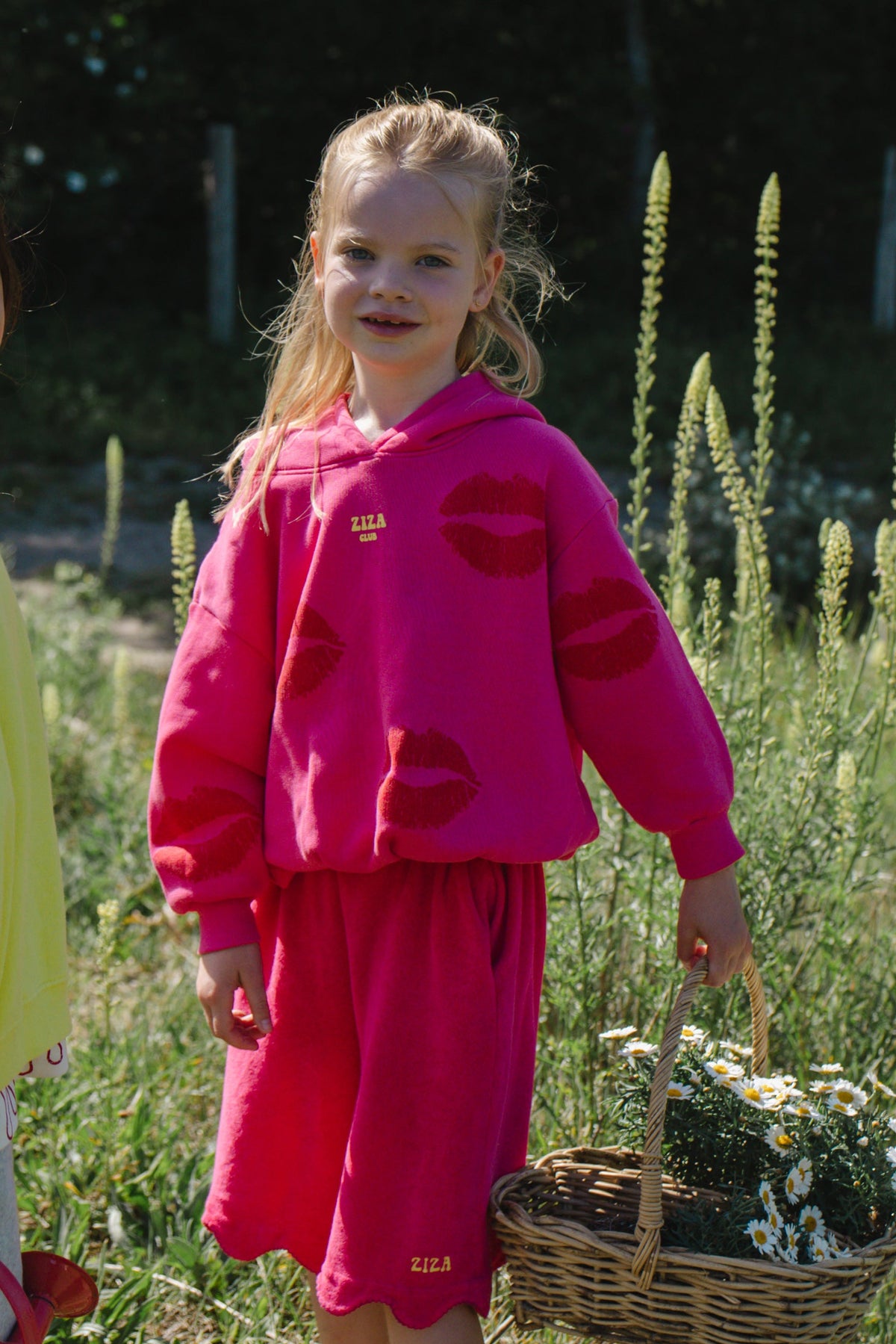 Kid wearing the ZIZA CLUB Hoodie KISS Bubble, a pink oversized kids hoodie with an all-over kiss print