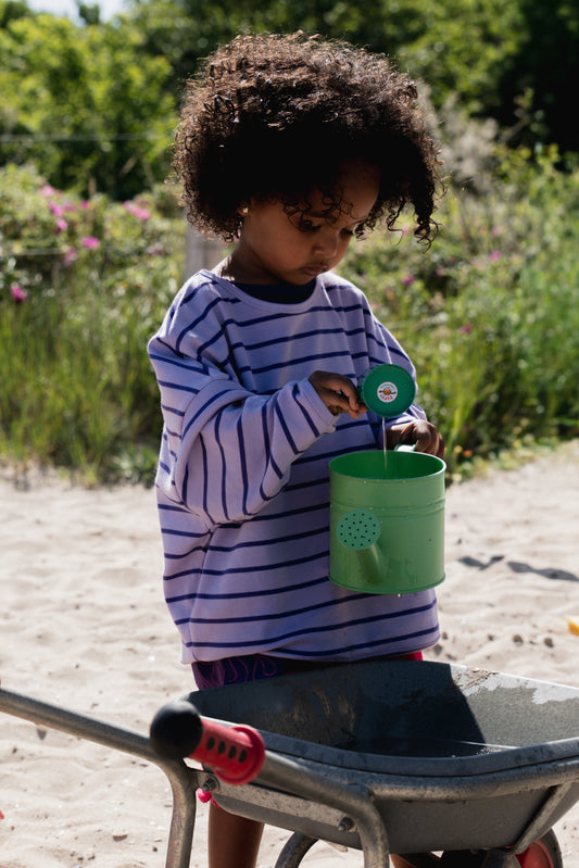 Kid wearing the ZIZA CLUB LS STRIPEY Macaron, a light and dark purple striped oversized kids longsleeve
