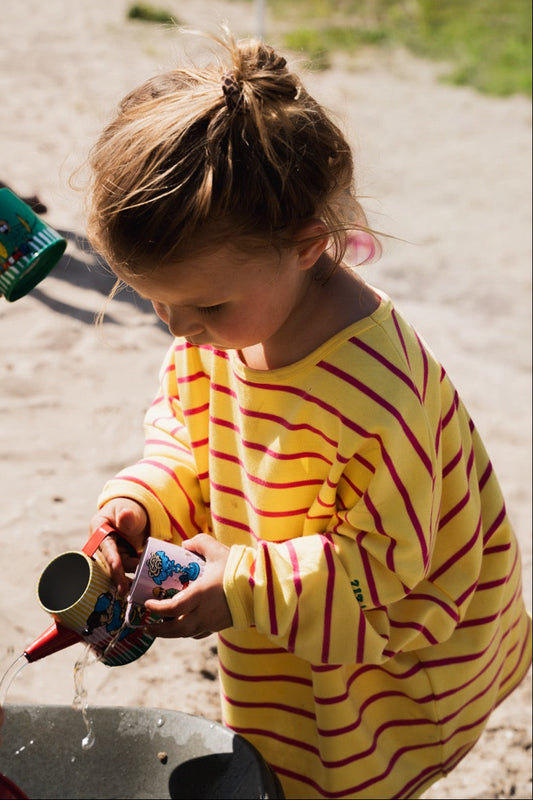 Kid wearing the ZIZA CLUB LS STRIPEY Sorbet, a yellow and pink striped oversized kids longsleeve