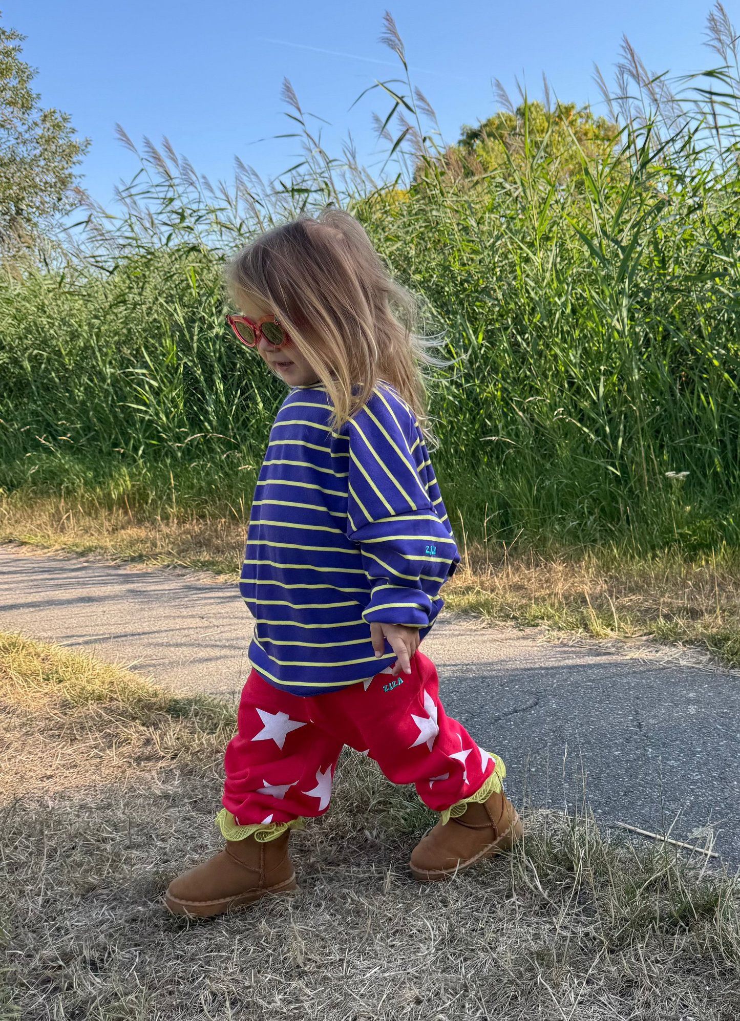 Kid wearing the ZIZA CLUB Jogger STARRY Tomato, red kids joggers with an all-over star print