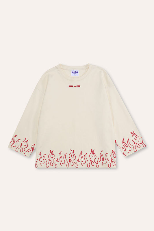 Kid wearing the ZIZA CLUB LS LOVE ON FIRE Cream, a cream oversized kids longsleeve with flame print hem